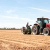 Field crew prepares uniform rows with a tractor-mounted planter, laying the groundwork for the integrated pest management experiments at Maricopa Agricultural Center..